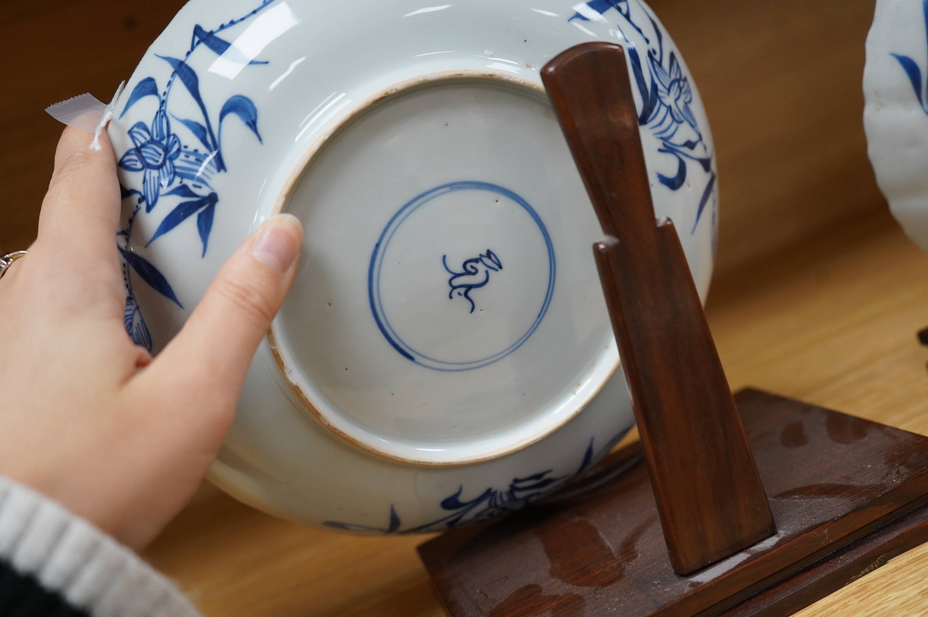 Two Chinese blue and white ‘astor’ plates, Kangxi period, with hardwood stands, largest 22cm diameter. Condition - poor to fair